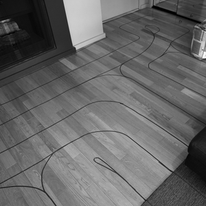 photograph of a section of floor in the artist's apartment, covered in lines of blue tape used to form the labyrinth